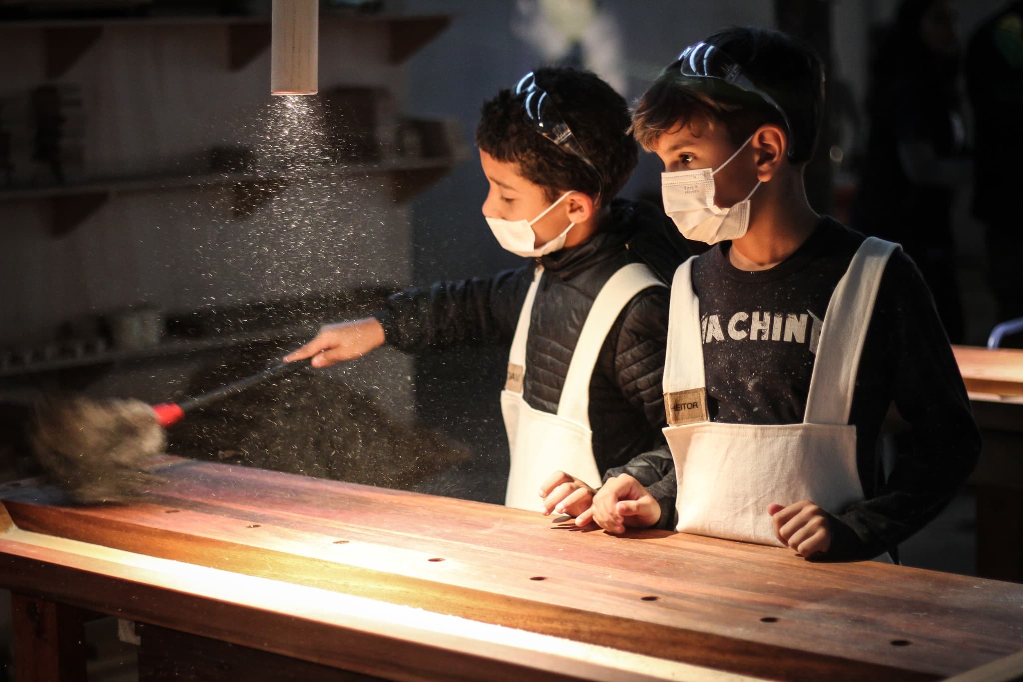 Children observing wood dust in the PHILIA LAB workshop